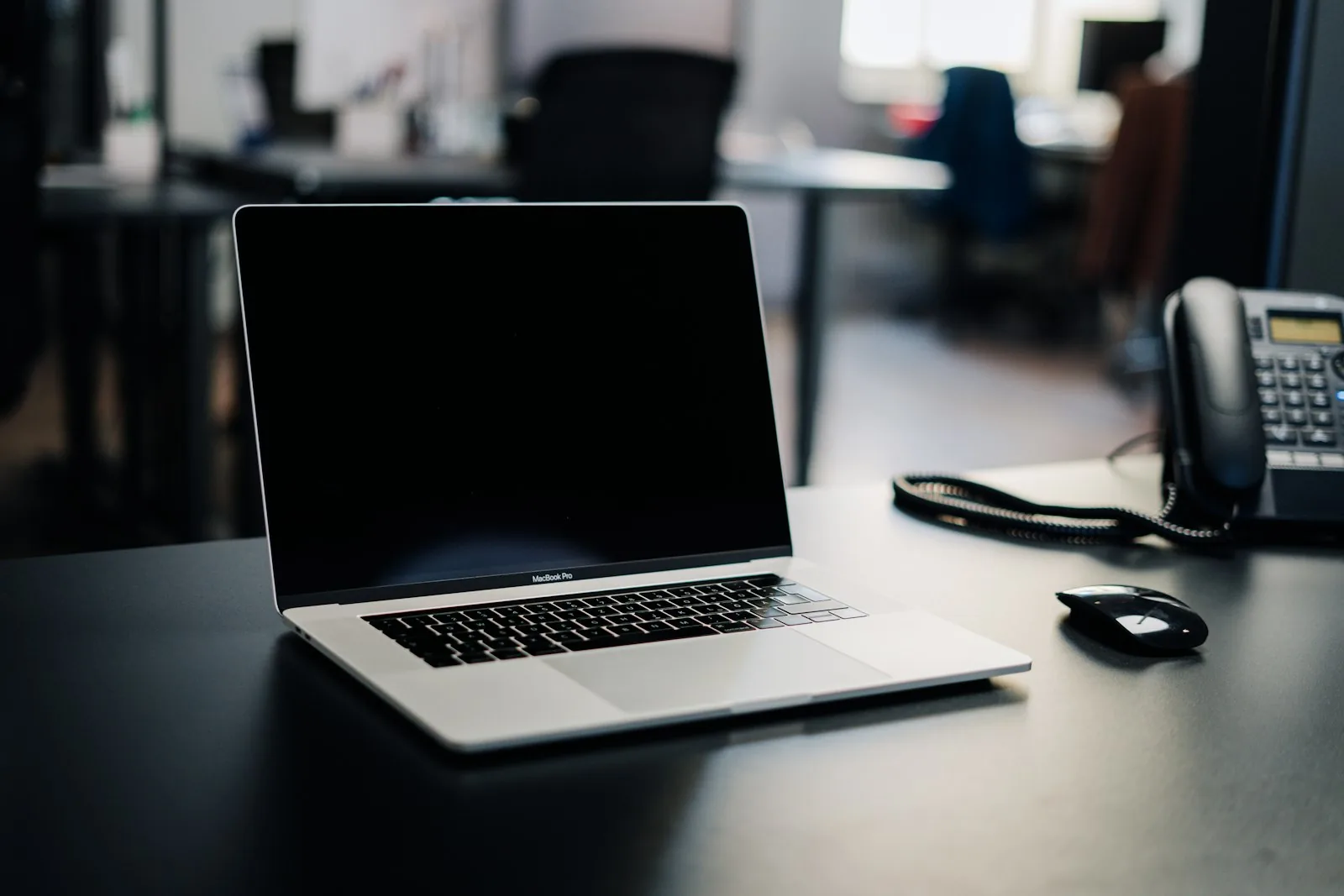 Business desk with a laptop and IP desk phone, ready for a cloud phone system